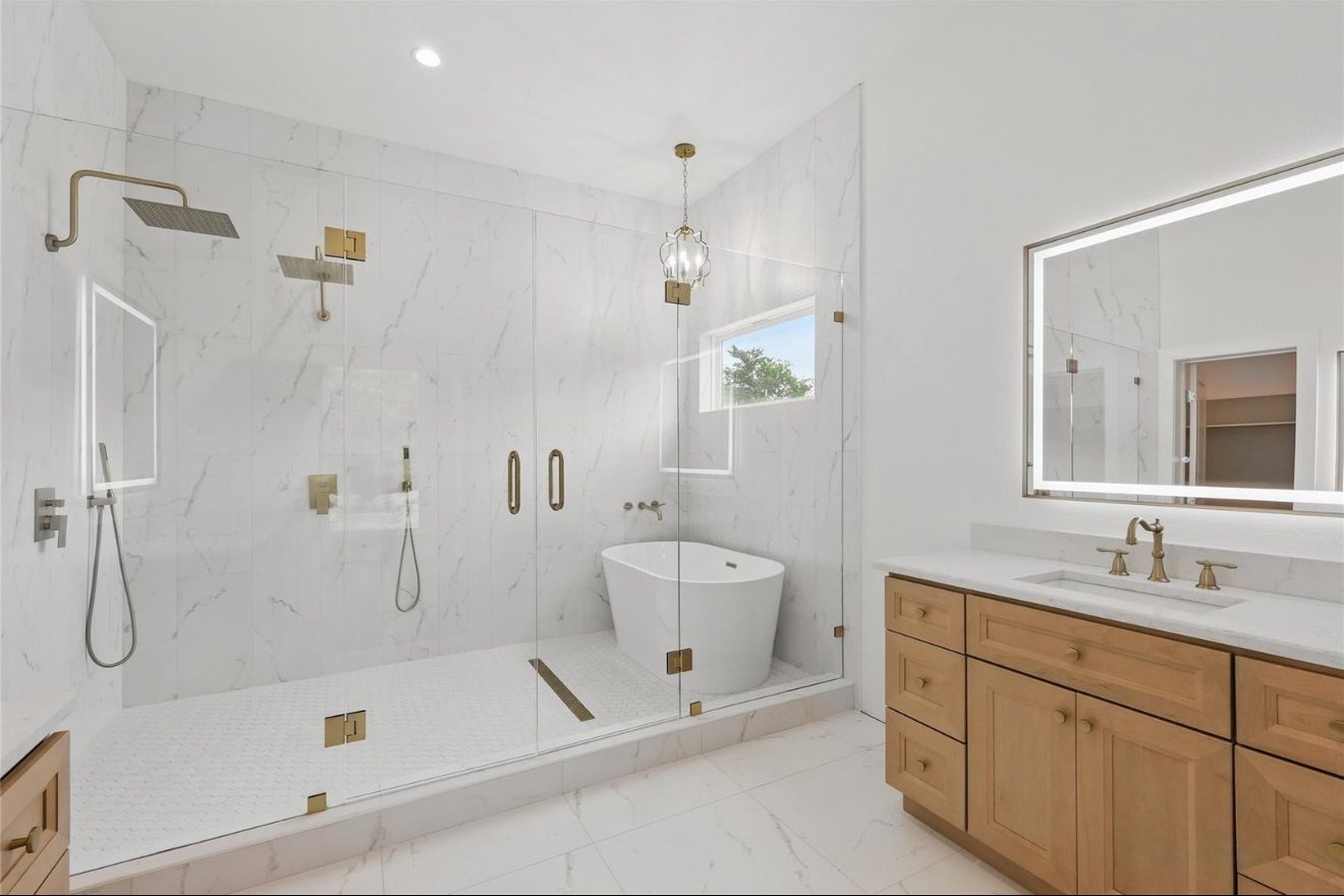 Primary bath with marble wet room and freestanding tub