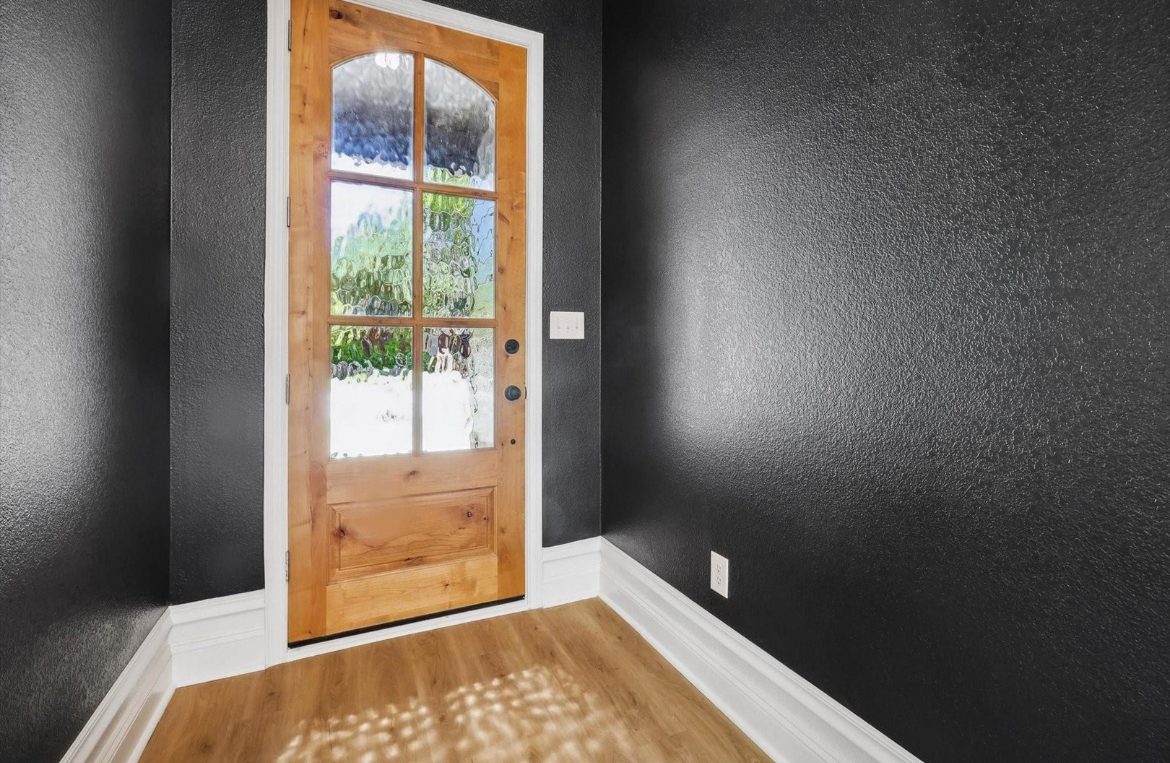 Entry with wood door and black accent wall