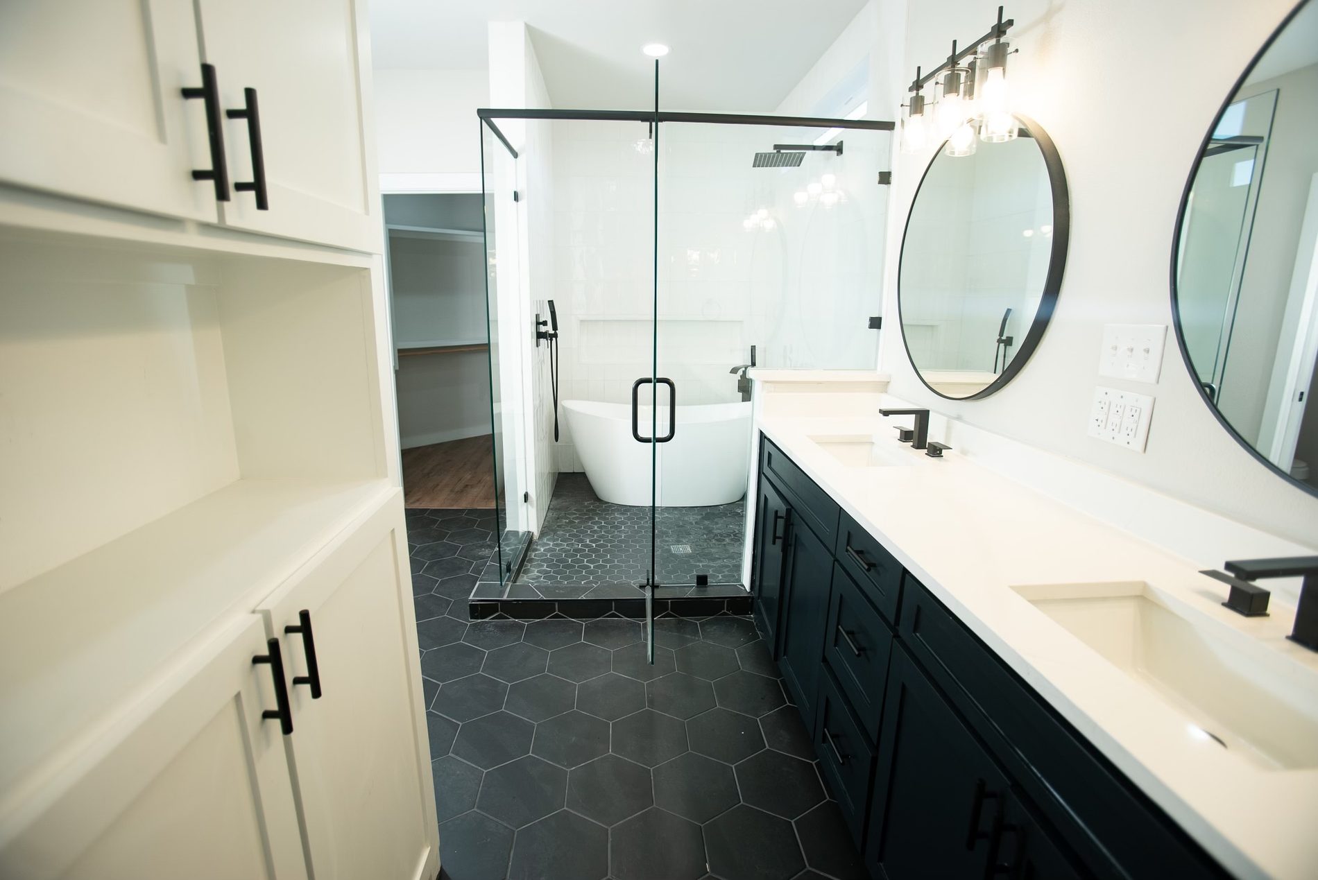 Primary bath with hex tile floor and navy vanity