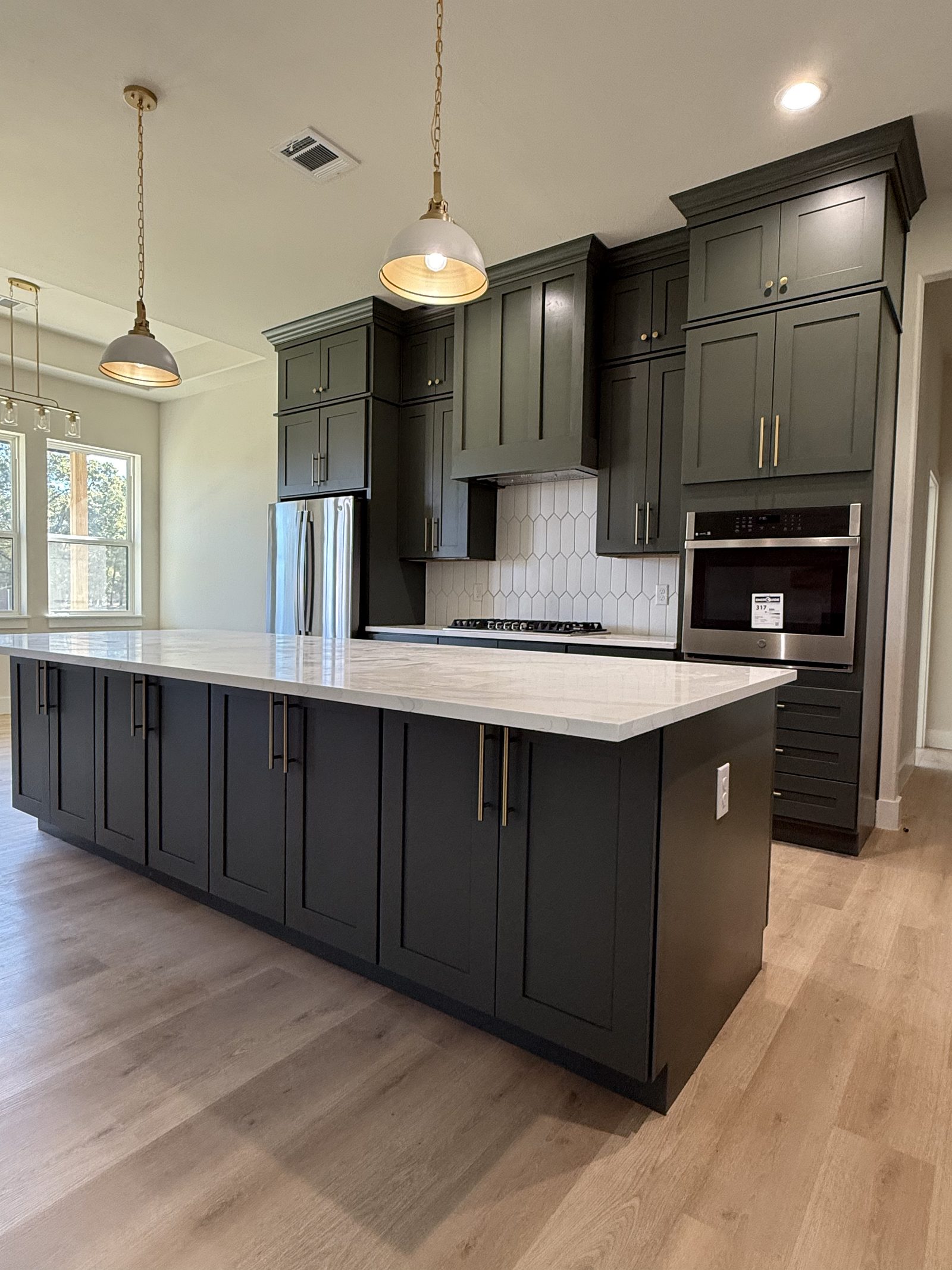 Kitchen with green cabinetry and quartz island